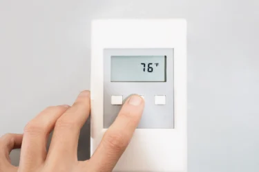 a person adjusting thermostats